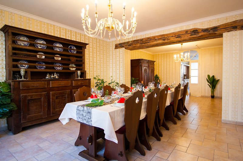 Intérieur élégant avec mobilier en bois, chandelier et décoration florale.