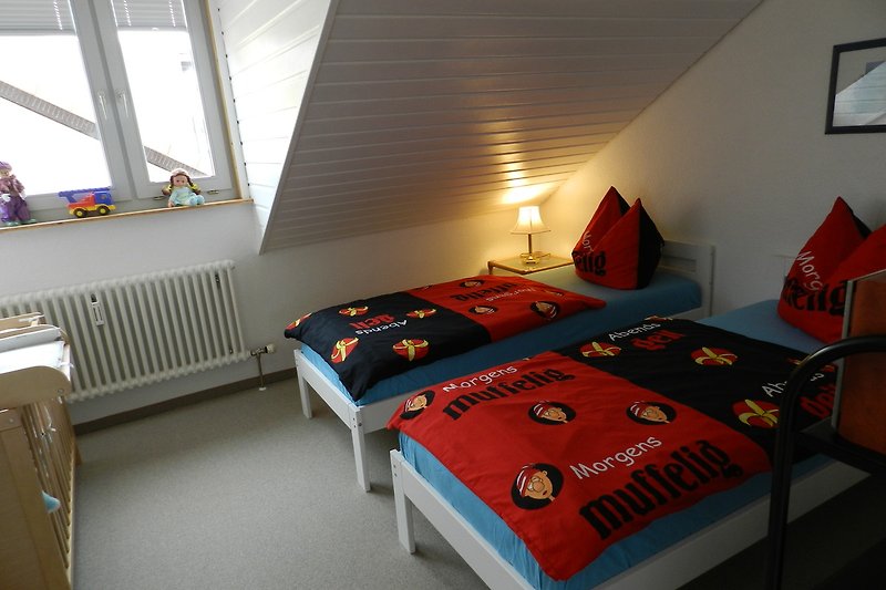 Kinderzimmer bestückt mit 2 Einzelbetten 90x200 cm und einem Kinderbett 70x140cm