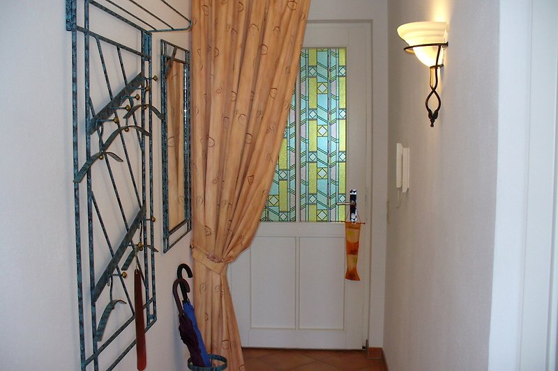 Eingangsbereich - mit Flurgarderobe und Spiegel sowie Schirme für unsere Gäste