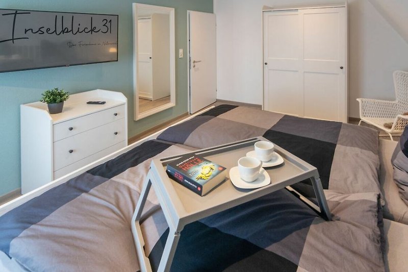 Gemütliches Schlafzimmer mit Doppelbett und Smart-TV