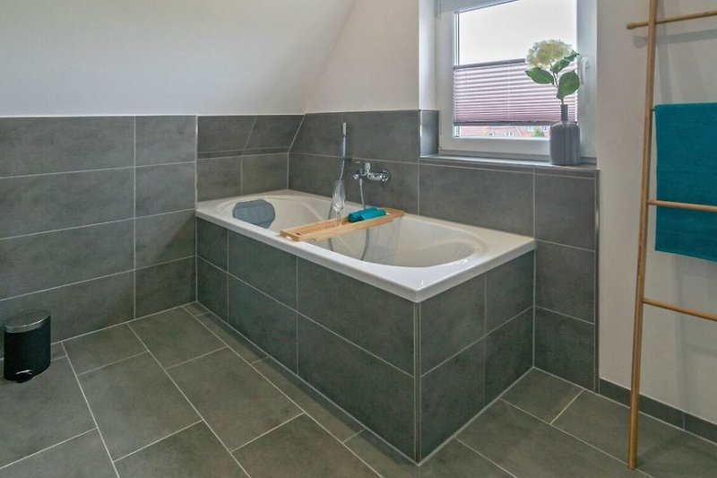 Stilvolles Badezimmer mit elegantem Waschbecken, Fliesen und Fenster.