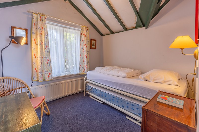 Comfortabel bed en houten interieur in prachtige slaapkamer.