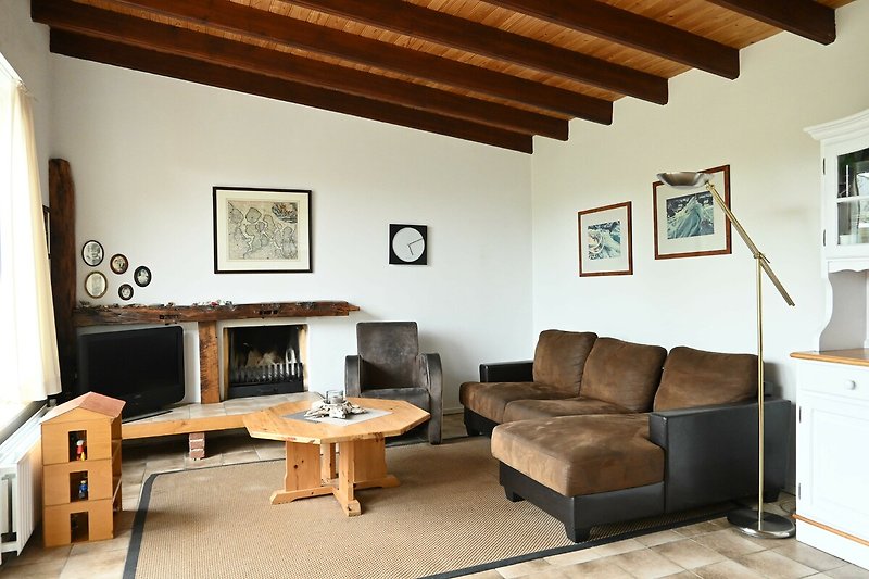 Mooi verlichte woonkamer met comfortabel meubilair en houten accenten.