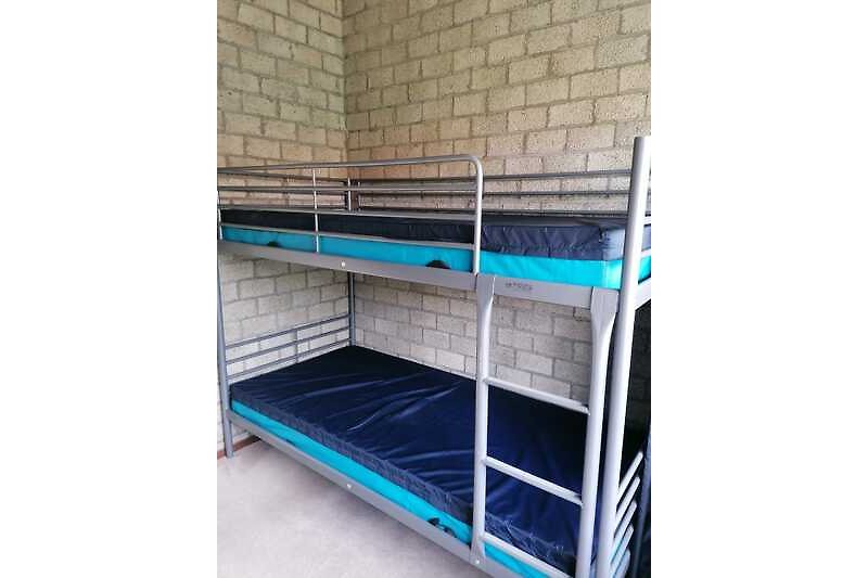 Een stijlvolle slaapkamer met een metalen bedframe en houten vloer.