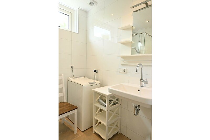 Mooie badkamer met houten vloer, spiegel en wastafel.