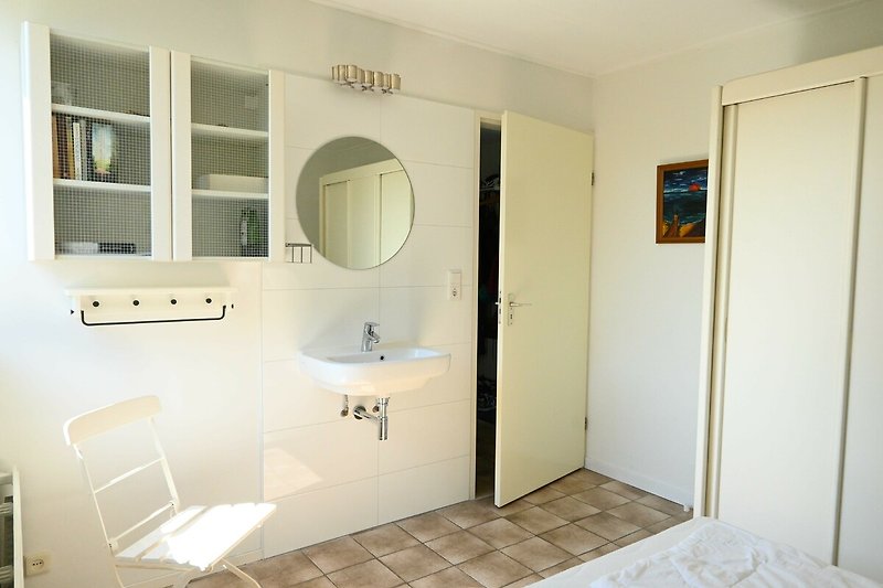 Prachtige badkamer met houten vloer en keramische wastafel.
