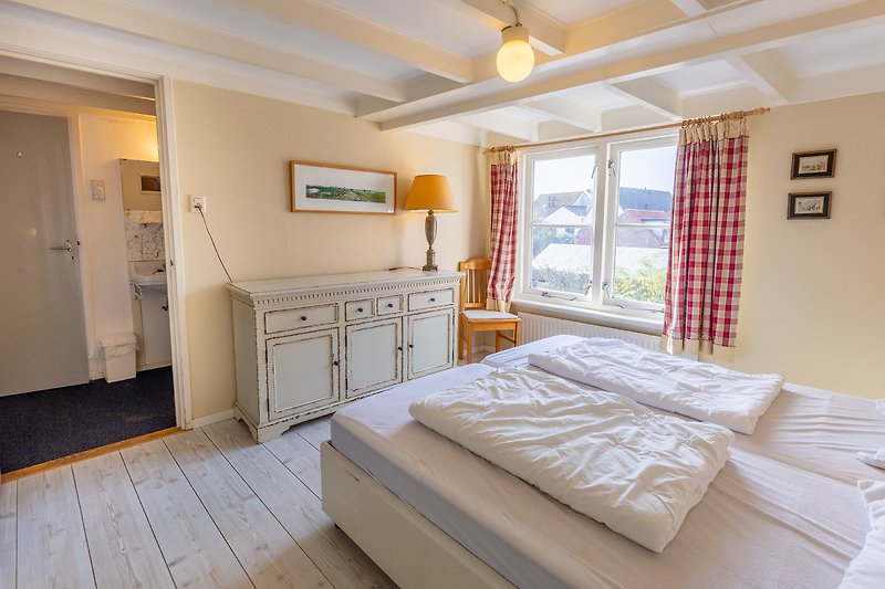 Mooi verlichte slaapkamer met houten meubels en comfortabel bed.