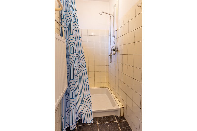 Prachtige badkamer met paarse accenten en houten vloer.