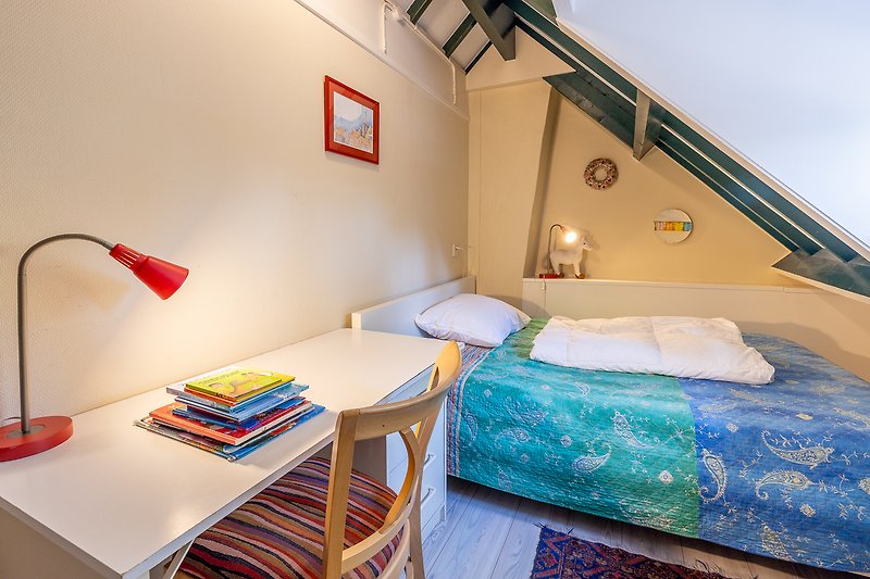 Mooi verlichte slaapkamer met comfortabel bed en houten meubels.