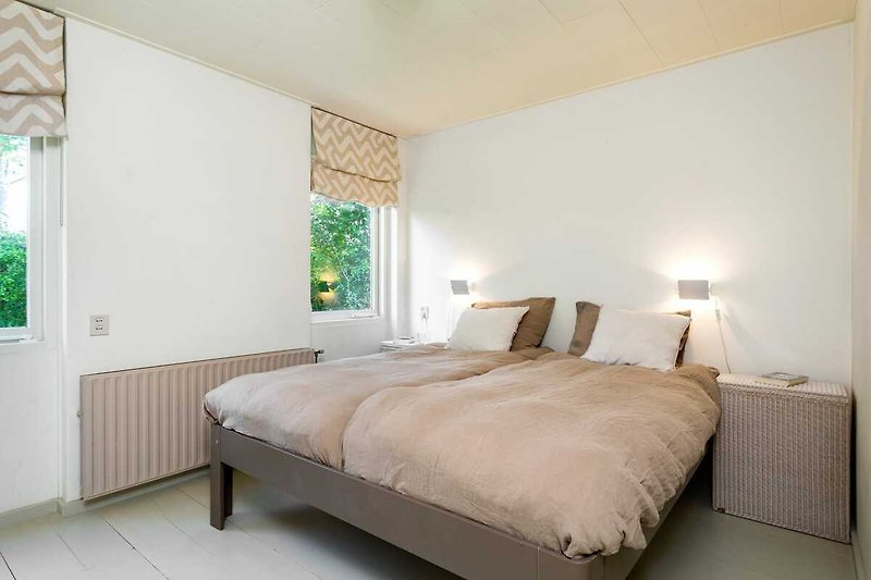 Comfortabele slaapkamer met houten meubels en groene accenten.