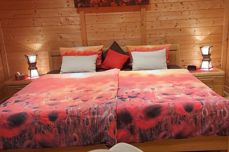 Gemütliches Schlaf-Wohnzimmer mit großem Bett und Topperauflage