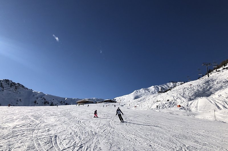 Beeindruckende Winterlandschaft mit schneebedeckten Bergen und Skiausrüstung.
