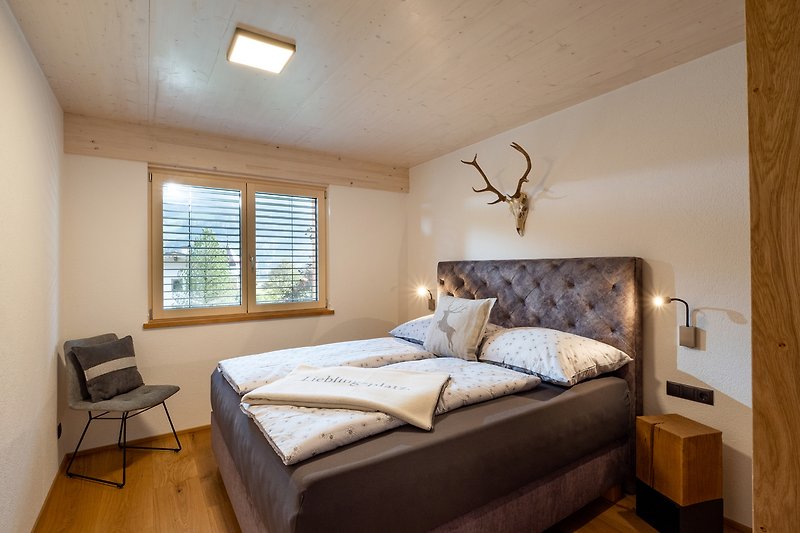 Ein stilvolles Schlafzimmer mit gemütlichem Bett und Holzmöbeln.