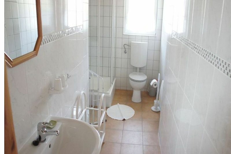 Schönes Badezimmer mit Fenster, Waschbecken und Dusche u. WC.