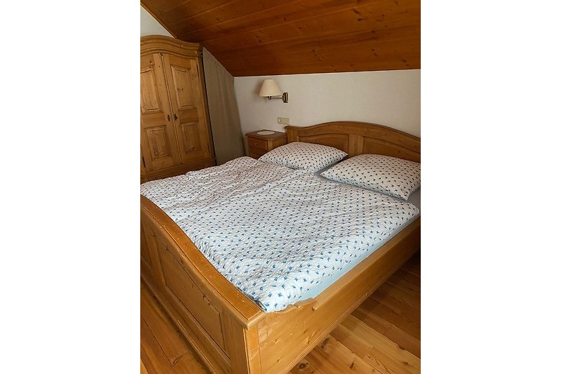 Schlafzimmer mit bequemem Bett und stilvoller Holzeinrichtung.