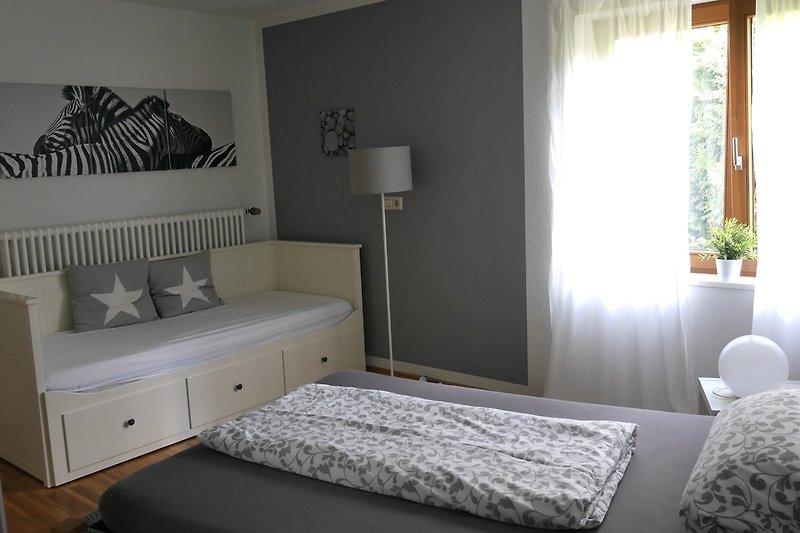 Gemütliches Schlafzimmer mit elegantem Möbelstück und stilvoller Fensterdekoration.