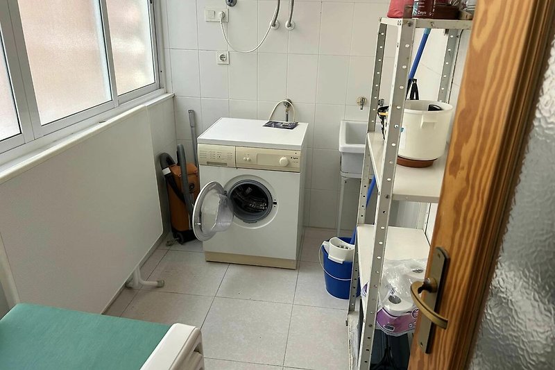 Waschküche mit Waschmaschine und Fenster zum Lichthof