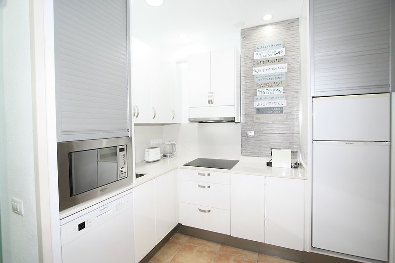 Moderne Küche mit grauen Schränken, Holzboden und Glasfronten.