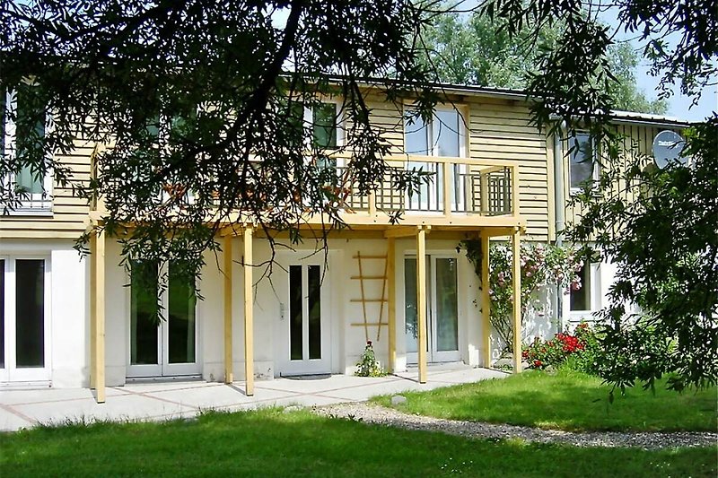 Gemütliches Haus mit Veranda, gepflegtem Garten und großer Rasenfläche.