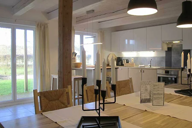 Geräumiges Wohnzimmer mit Holzbalken und stilvoller Beleuchtung.