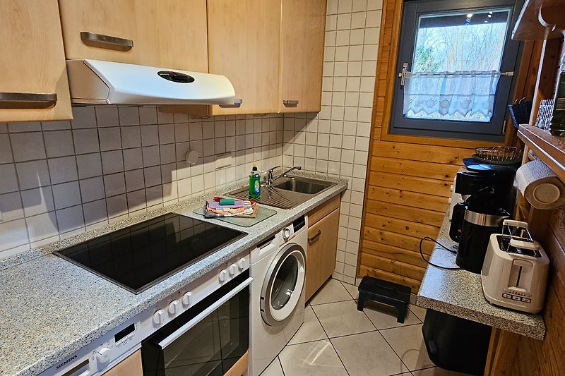 Moderne Küche mit Waschmaschine, Geschirrspüler, Mikrowelle, Kaffeemaschine, Toaster