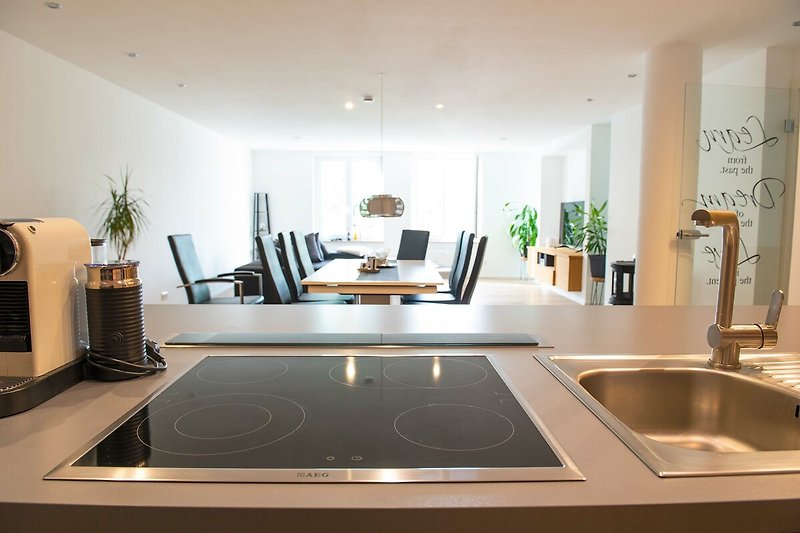 Gemütliche Küche mit modernem Design, Holzboden und stilvoller Beleuchtung.