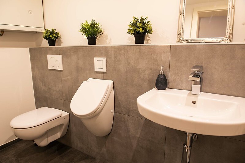 Stilvolles Badezimmer mit modernem Design, Holzboden und elegantem Waschbecken.