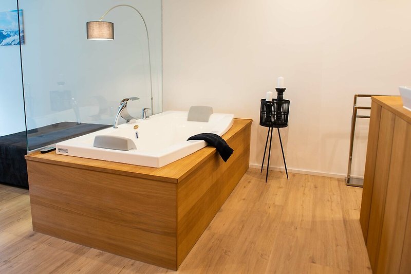 Ein stilvolles Badezimmer mit Holzboden, Badewanne und modernen Armaturen.