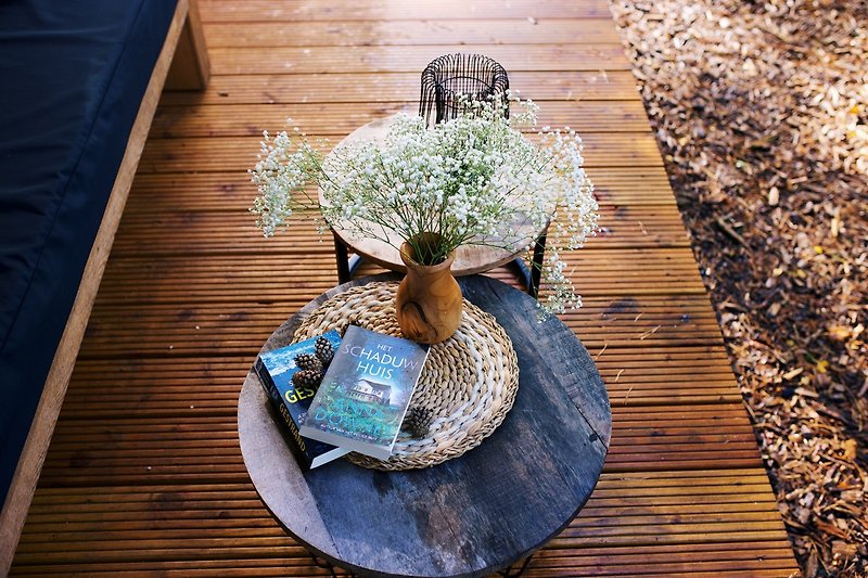 Een idyllische tuin met een houten tafel en bloemen.