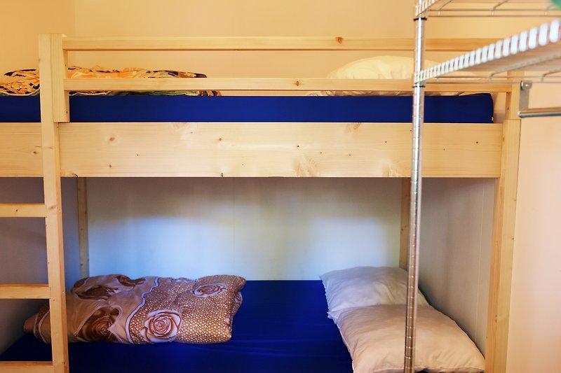 Comfortabele slaapkamer met houten bedframe en beddengoed.