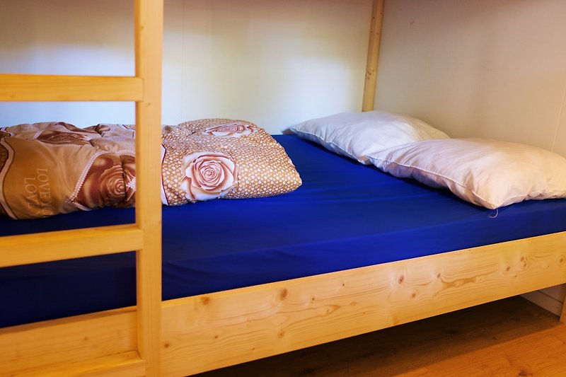 Een comfortabele slaapkamer met een houten bedframe en beddengoed.