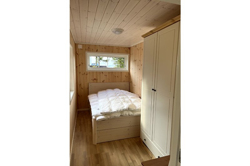 Gemütliches Zimmer mit Holzbalken, Tageslicht und schönen Holzböden.