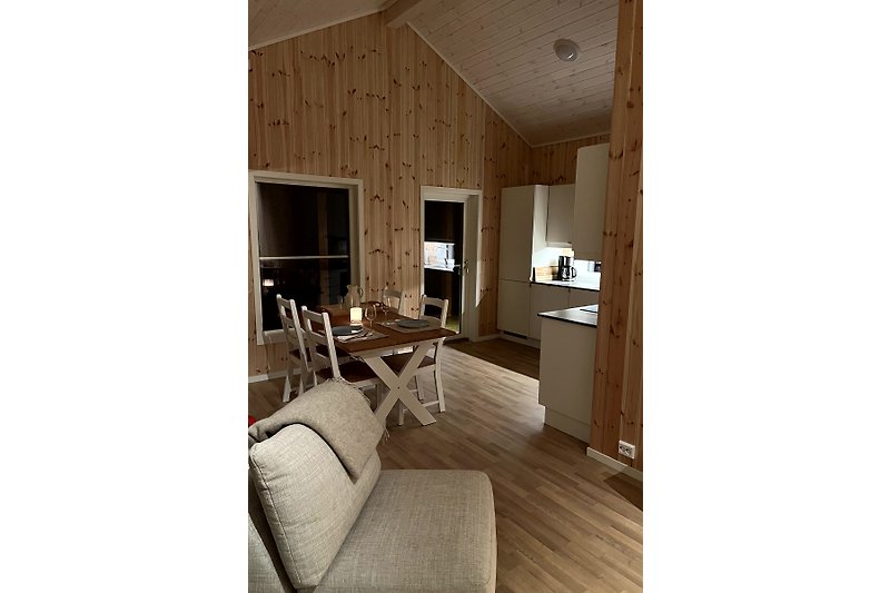 Gemütliches Wohnzimmer mit Holzmöbeln und Tageslicht.