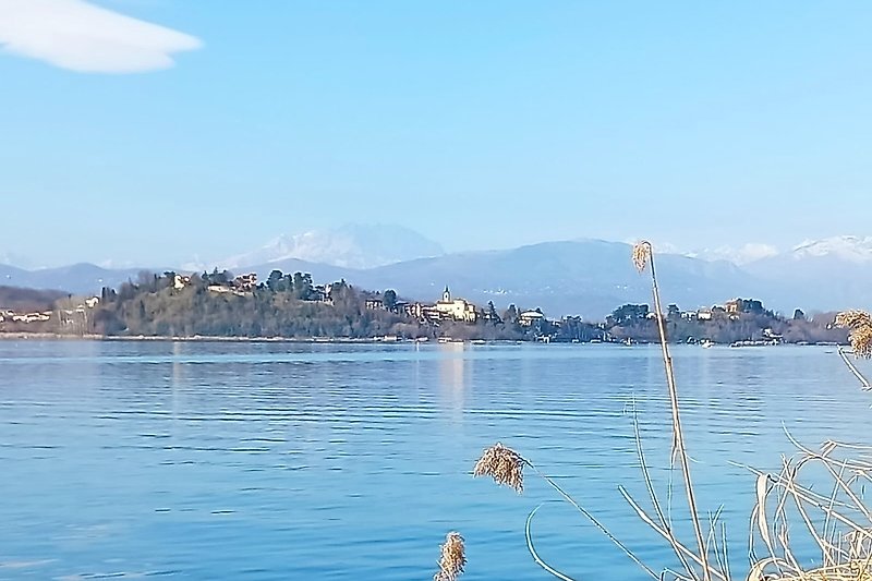 Una vista panoramica sul lago con montagne e cielo azzurro.