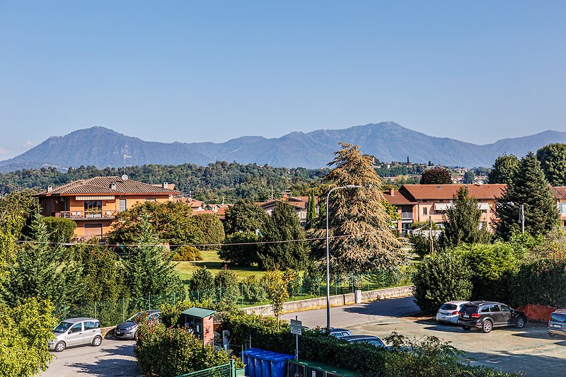 Una vista panoramica di una città con montagne e un cielo azzurro.