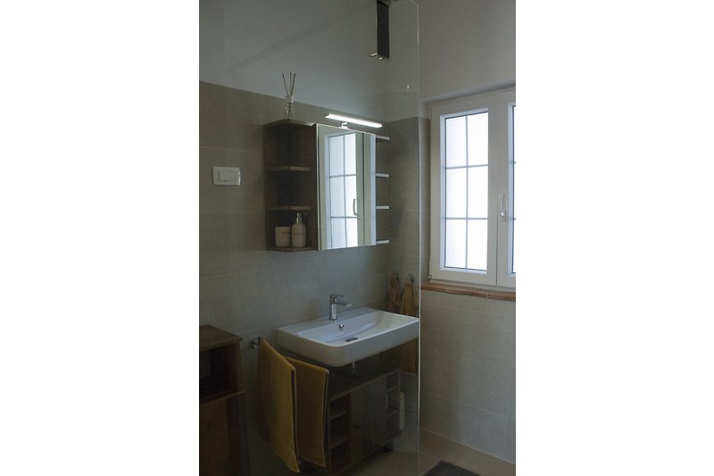 Stilvolles Badezimmer mit elegantem Spiegel und modernem Waschbecken.