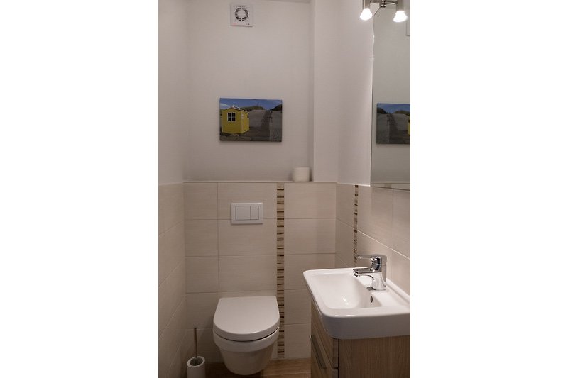 Kleines Badezimmer mit WC und Handwaschbecken.