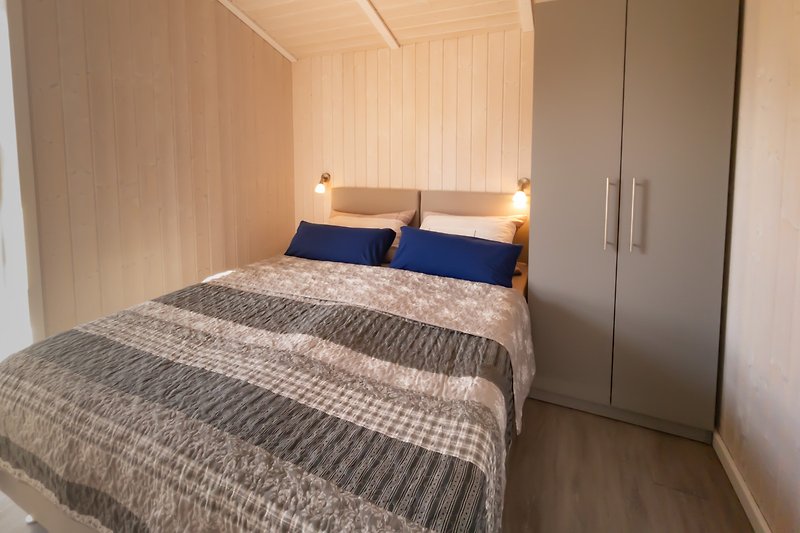 Stilvolles Schlafzimmer mit bequemem Bett und Holzmöbeln.