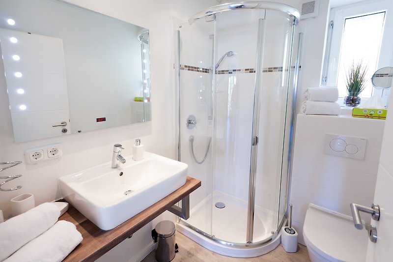 Modernes Badezimmer mit lila Akzenten, Dusche, Spiegel und Badewanne.