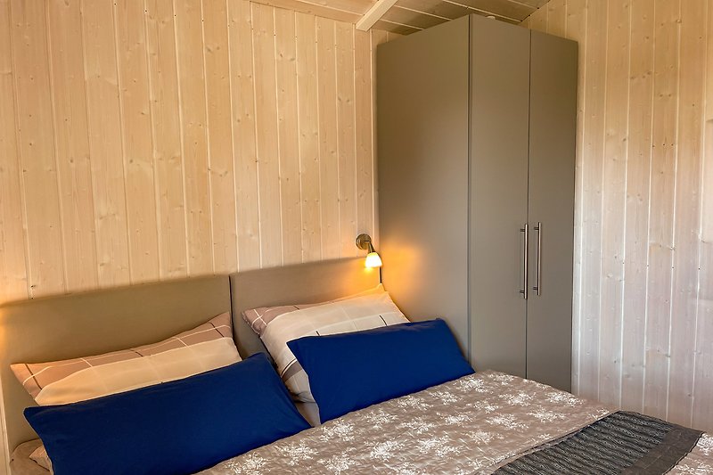 Gemütliches Schlafzimmer mit stilvollen Holzmöbeln und bequemem Bett.