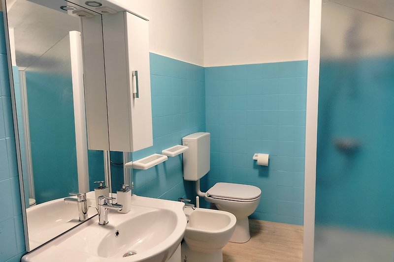Moderne Badezimmerausstattung mit Spiegel, Waschbecken und Armatur. Sauber und stilvoll.