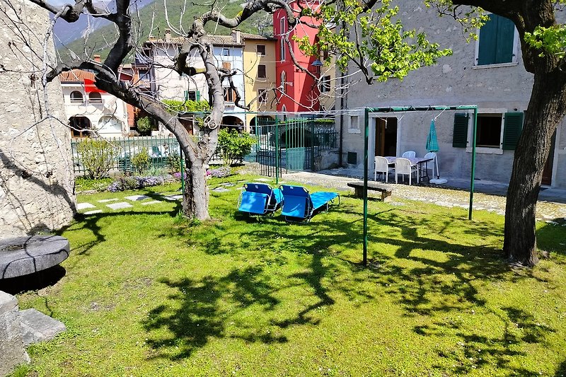 Gemütliches Haus mit grünem Garten und blauem Himmel. Natur, Ruhe und Entspannung.