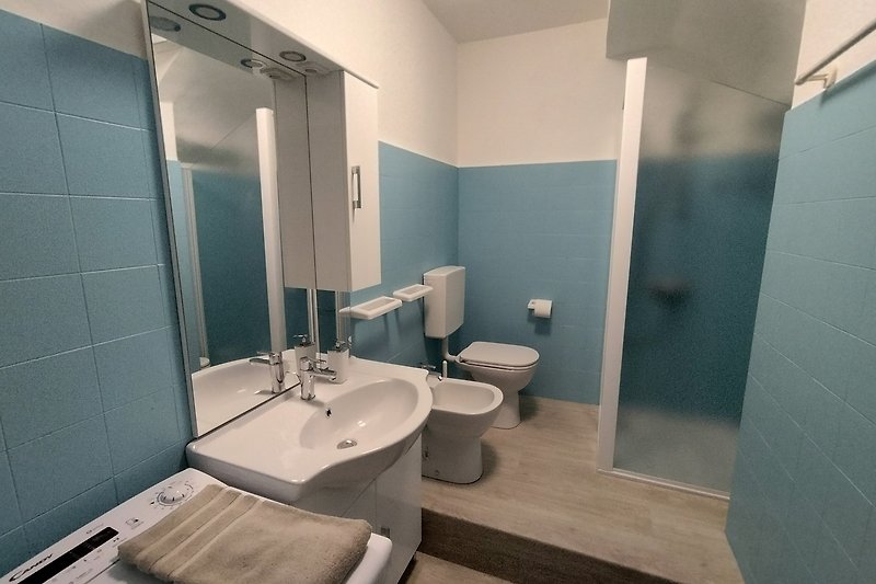 Ein stilvolles Badezimmer mit Spiegel, Waschbecken und Armatur. Sauber und modern.
