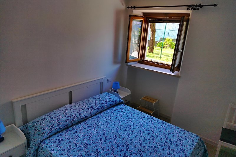 Gemütliches Schlafzimmer mit blauem Bett und Holzboden.