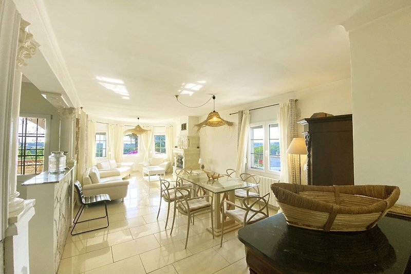 Vaste salon salle à manger avec mobilier de qualité, éclairage chaleureux et décoration élégante.