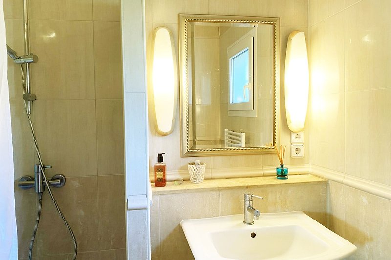 Magnifique salle de douche avec miroir, lavabo et robinetterie. Design intérieur élégant.