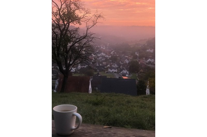 Een sfeervolle ochtend met een kopje koffie en uitzicht op de bergen.