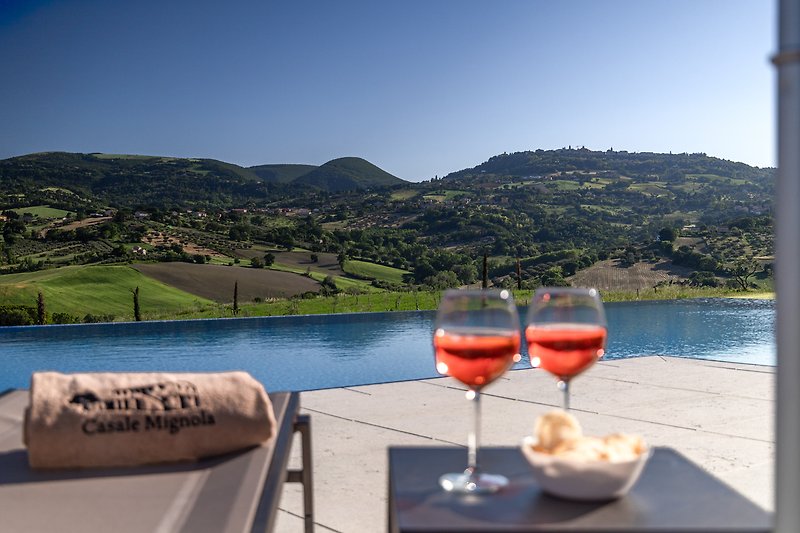 an amazing view on the hills of Le Marche Region , with a table set for a relaxing drink.