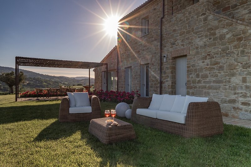 A cozy outdoor seating area with a view of the beautiful garden and surrounding landscape.
