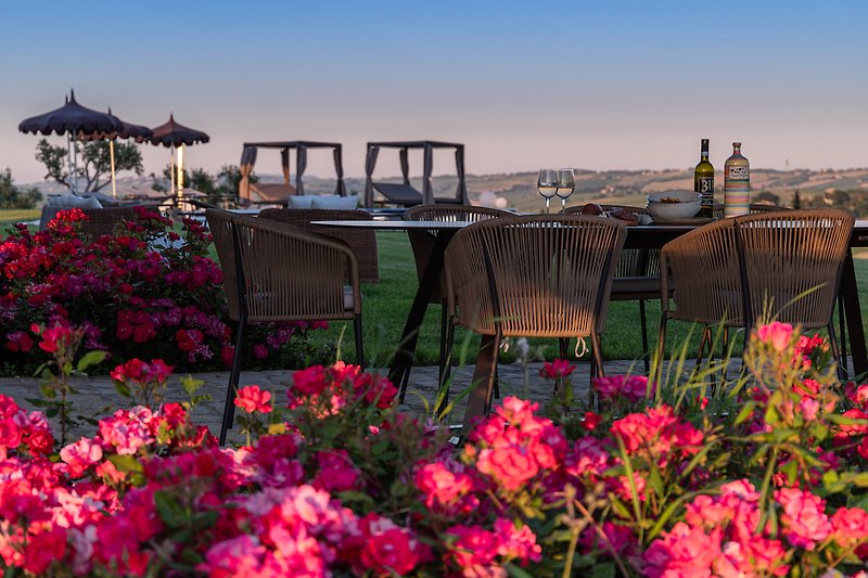 Escape to a paradise with a vibrant garden, hills view, and cozy seating.